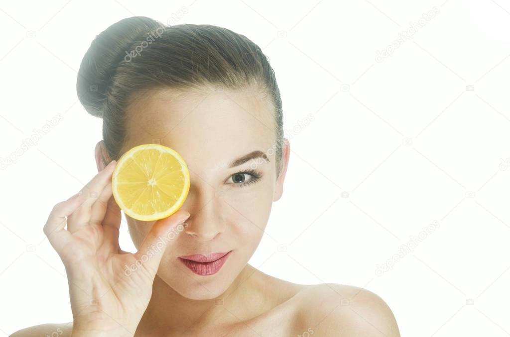 Young mysterious woman looks at the photographer through a slice of lemon