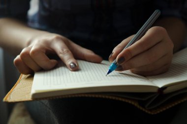 Bir kız ona kucak ve yazma bir defter tutuyor