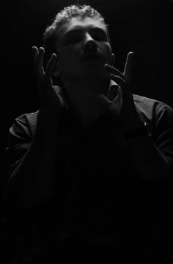 Adam ellerini kaldırdı, başını kaldırdı ve gözleri, bir şey hakkında düşünüyor kapalı