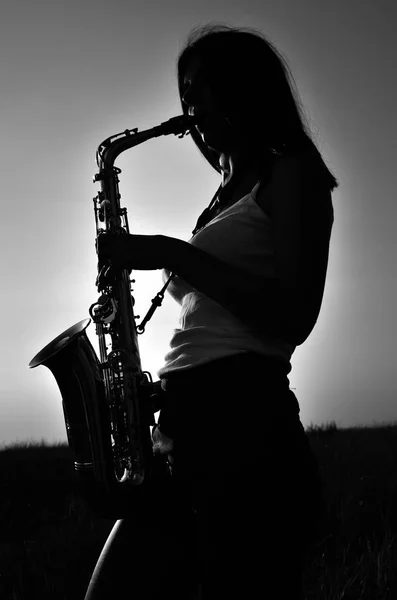 Młoda dziewczyna gra na saksofonie o charakterze — Zdjęcie stockowe