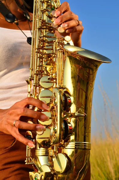 Women's hands and saxophone — Stock Photo, Image