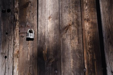 Metal zımba küçük demir kilit üzerinde yüksek ahşap kapı kilitleniyor