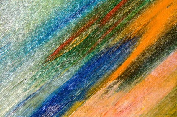 Watercolor strokes on a cardboard cloth: many blue, green, orange, light.