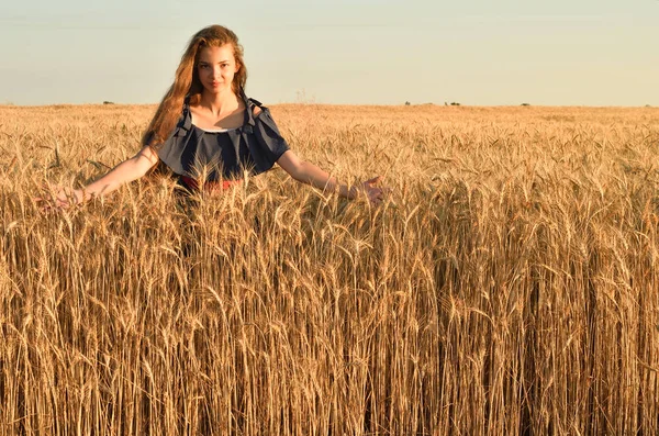 Uma jovem mulher com o cabelo destorcido em pé no campo — Fotografia de Stock
