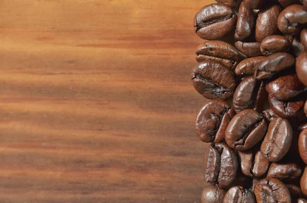 Seçili kahve kavrulmuş fasulye bir ahşap arka plan üzerinde yalan söylüyorsun. — Stok fotoğraf