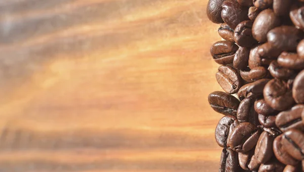 Hafif Ahşap Arka Plan Üzerinde Büyük Kavrulmuş Kahve Çekirdekleri Arka — Stok fotoğraf