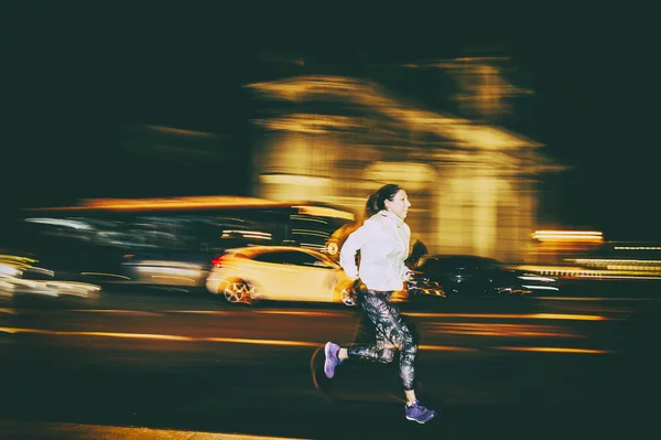 Woman practicing running in the city at night — Stock Photo, Image