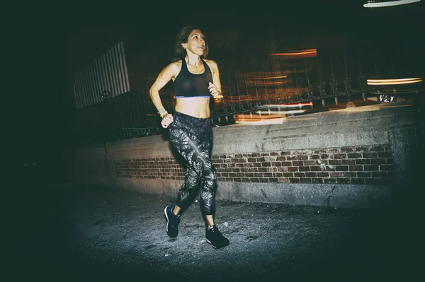 Žena cvičí běží ve městě v noci — Stock fotografie