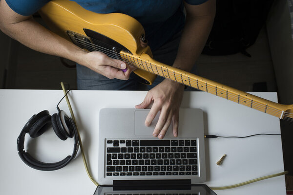 Man teaching himself to play guitar at home