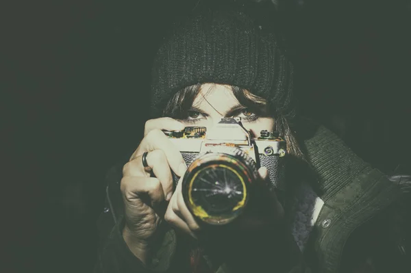 Женщина смотрит со старым фотоаппаратом — стоковое фото