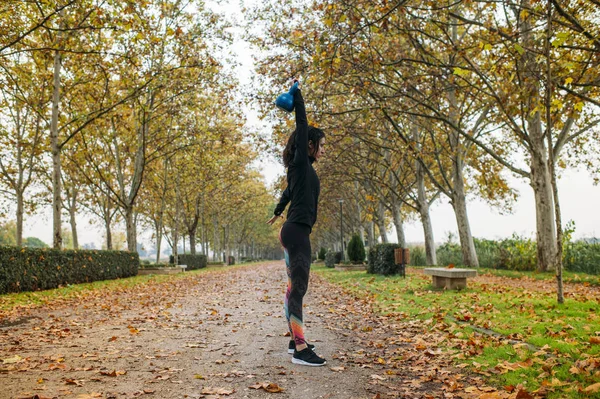 Mulher praticando kettlebell no parque — Fotografia de Stock