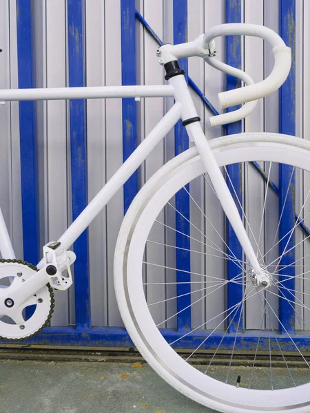Vit cykel av staden fast redskap på vita och blå vägg. — Stockfoto