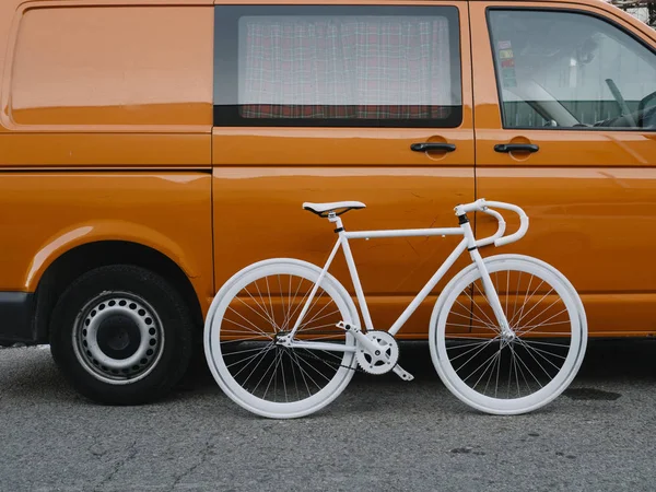 市固定齿轮橙色货车上的白色自行车. — 图库照片