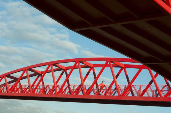 Mladý muž běžící na červený most — Stock fotografie