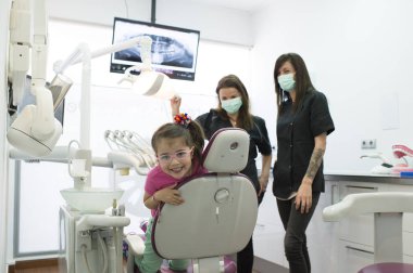 Diş hekimleri çocuk diş bir müdahale sırasında bir hastayla