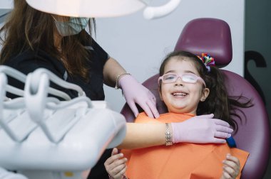 Diş hekimleri çocuk diş bir müdahale sırasında bir hastayla