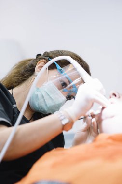 Diş hekimleri diş bir müdahale sırasında bir hastayla.