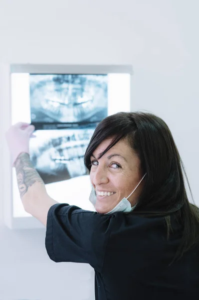 Vrouwelijke arts-tandarts kijken x-ray — Stockfoto
