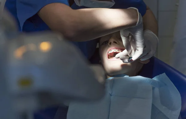 Dokter gigi dengan pasien selama intervensi gigi untuk anak laki-laki — Stok Foto