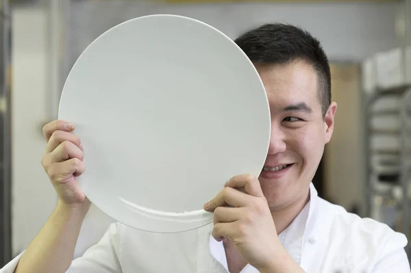 Os chineses cozinham com a placa na frente do rosto — Fotografia de Stock