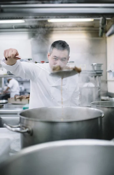 Chinese cook preparing stew in the pan