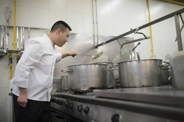 Chinese cook preparing stew in the pan