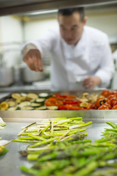 chinese cook adding salt to vegetables