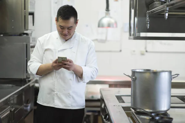 Cozinheiro chinês com smartphone — Fotografia de Stock