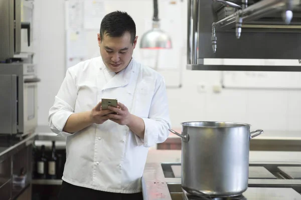 Cozinheiro chinês com smartphone — Fotografia de Stock