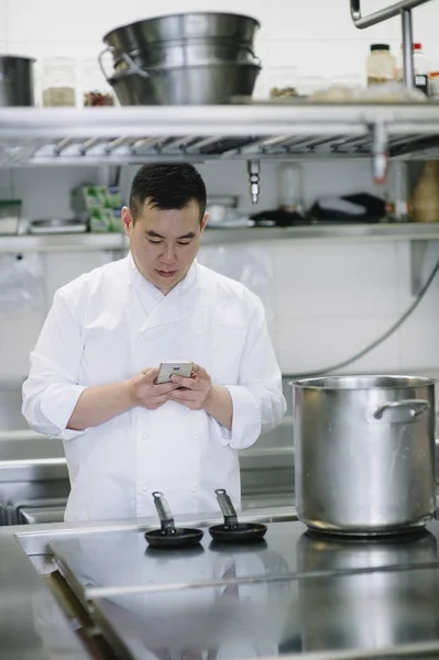 Cozinheiro chinês com smartphone — Fotografia de Stock