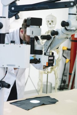 Mikroskop ve bir iskelet bakar laboratuvar bilim adamı 