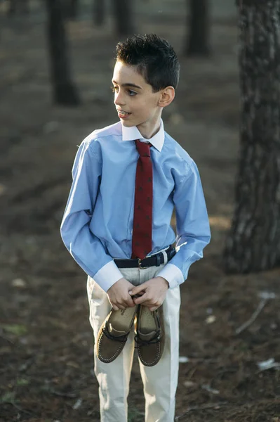 Niño elegante con zapatos en la mano —  Fotos de Stock