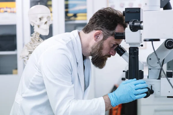 Scientifique en laboratoire regardant au microscope — Photo