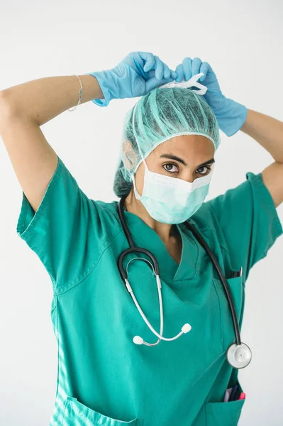 Femeie asistentă medicală care leagă o mască chirurgicală — Fotografie, imagine de stoc