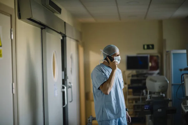 Доктор держит смартфон в коридоре — стоковое фото