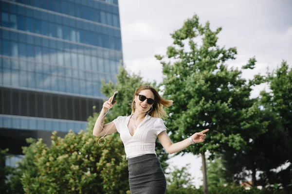 Jeune femme blonde écoutant de la musique en plein air — Photo