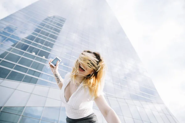 Jeune femme blonde écoutant de la musique en plein air — Photo