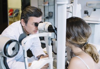 Göz doktoruna examinating genç bir hastaya