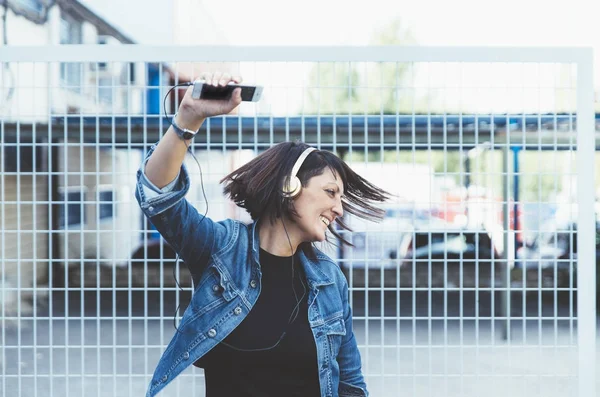 Sokak danci akıllı telefon ve kulaklık ile esmer kız — Stok fotoğraf
