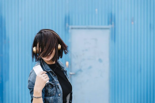 Brunetka dziewczynka z słuchawki i smartfon w ulicy danci — Zdjęcie stockowe