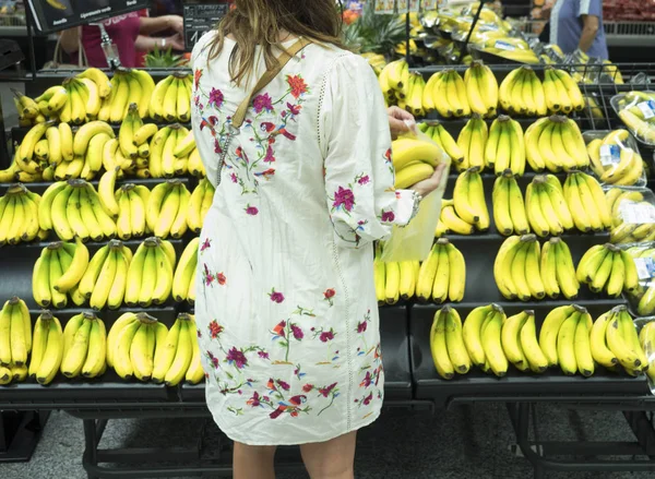Kobieta, która kupuje banany w super Markecie — Zdjęcie stockowe