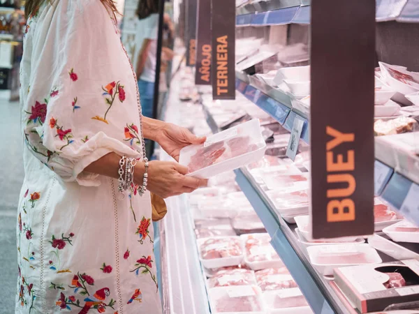 woman who buys  meat at the super market