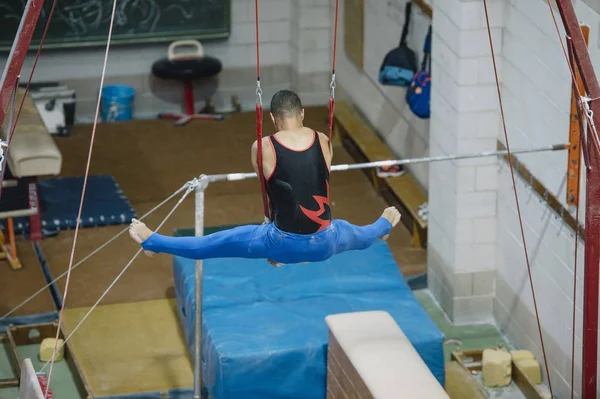 Male gymnast performing on gymnastic rings — Stock Photo, Image