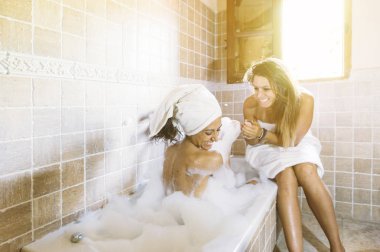 iki mutlu lezbiyen banyoda köpük ile oynamak