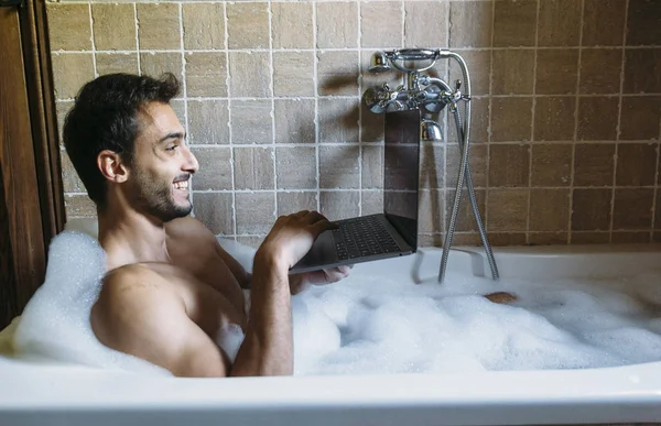 Nudo ragazzo in bagno con computer portatile — Foto Stock