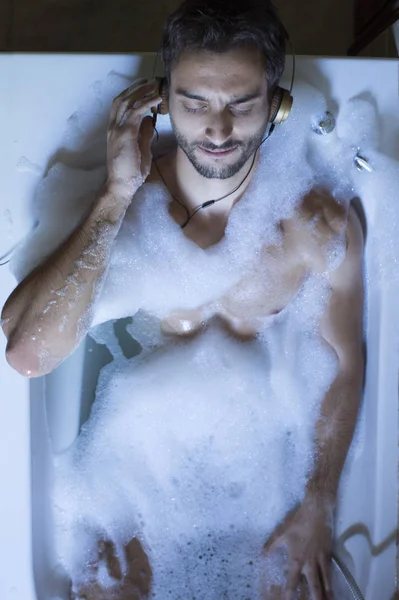 Nudo ragazzo in bagno con smartphone e cuffie — Foto Stock