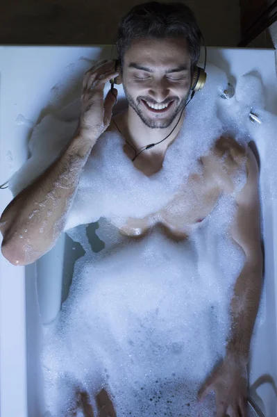 Nudo ragazzo in bagno con smartphone e cuffie — Foto Stock