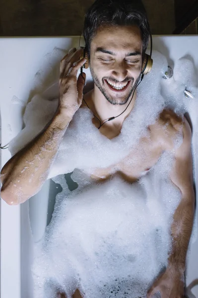 Nudo ragazzo in bagno con smartphone e cuffie — Foto Stock