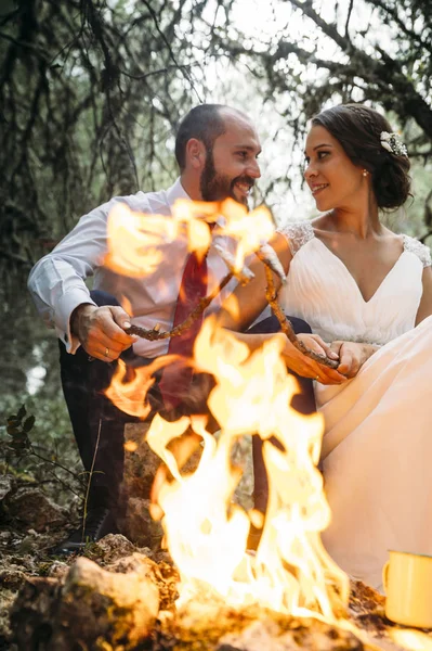 Szczęśliwa para siedzi na ławce w pobliżu ogniska — Zdjęcie stockowe