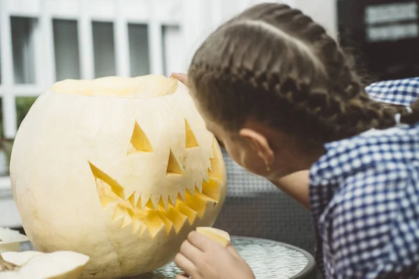 Menina esculpindo abóbora Halloween ao ar livre . — Fotografia de Stock